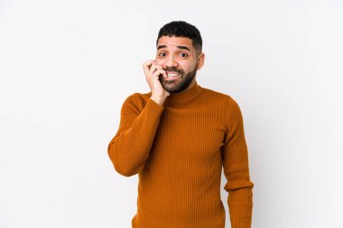 Beyaz bir geçmişi olan genç Latin bir adam tırnak yiyor, gergin ve endişeli..