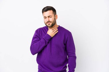 Beyaz arka planda yaşayan beyaz tenli genç bir adam virüs veya enfeksiyon yüzünden boğazında ağrı hissediyor..