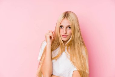 Pembe arka planda soyutlanmış genç sarışın kadın yüzü.