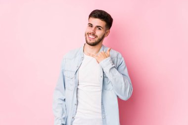 Pembe arka planda poz veren beyaz bir iş adamı.