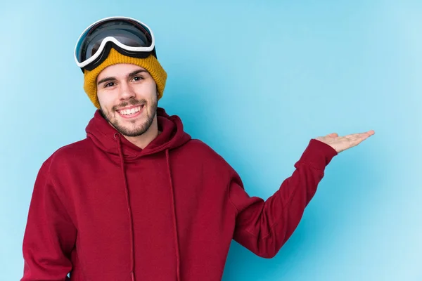 Jovem Caucasiano Vestindo Uma Roupa Esqui Isolado Mostrando Espaço Cópia — Fotografia de Stock