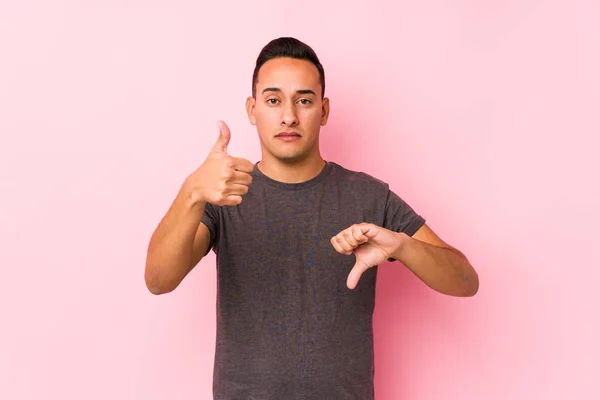 Yooung Latin Man Posing Pink Backgroundshowing Thumbs Thumbs Difficult Choose — 스톡 사진