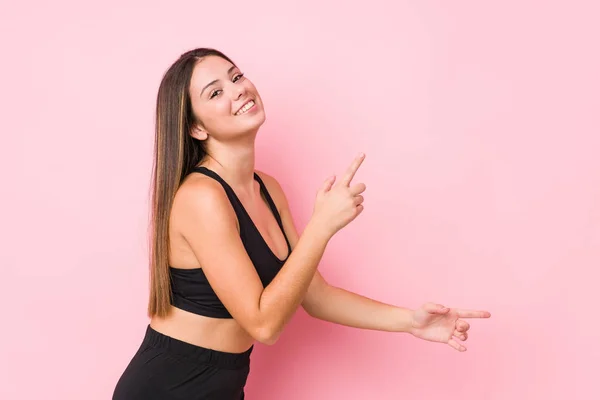 Young Fitness Caucasian Woman Isolated Excited Pointing Forefingers Away — Stock Photo, Image