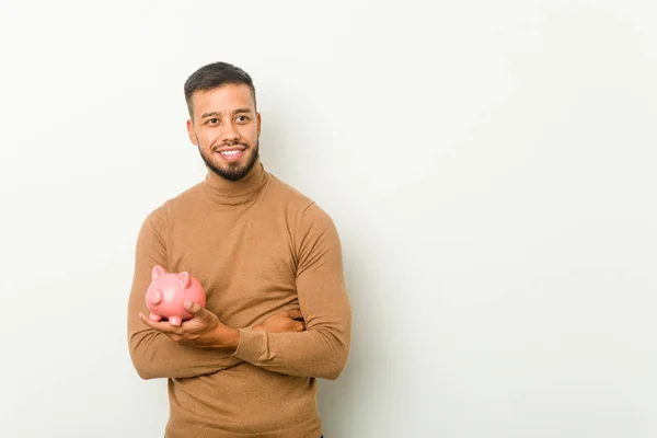 Young South Asian Man Holding Piggy Bank Smiling Confident Crossed — 스톡 사진