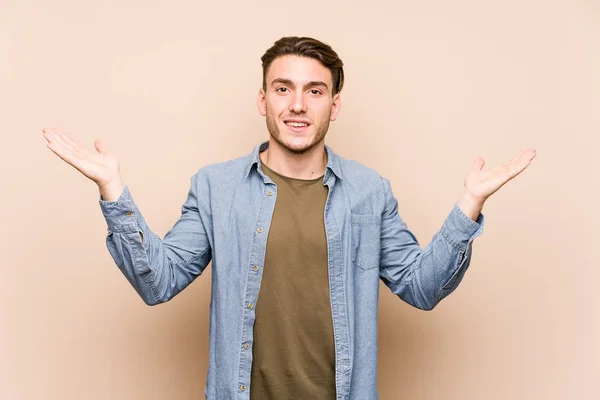 Young Caucasian Man Posing Isolated Makes Scale Arms Feels Happy — 스톡 사진