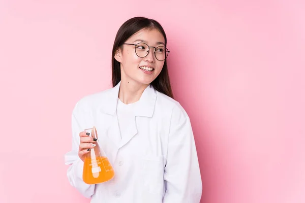 Young chinese scientific woman isolated looks aside smiling, cheerful and pleasant.