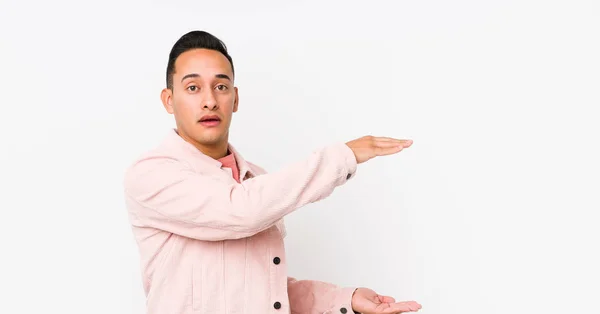 Young Latin Man Posing Isolated Shocked Amazed Holding Copy Space — 스톡 사진