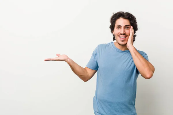 Jonge Knappe Man Tegen Een Witte Achtergrond Houdt Kopieerruimte Een — Stockfoto