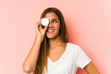 Genç, beyaz bir kadın pembe arka planda izole edilmiş bir mastürbasyoncu tutuyor.