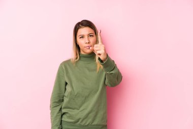 Genç beyaz kadın izole edilmiş poz veriyor. Bir numarayı parmağıyla gösteriyor..