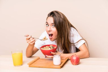 Genç beyaz kadın kahvaltı yapıyor.