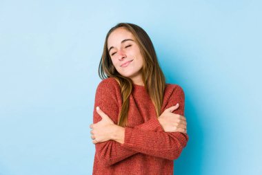 Kafkasyalı genç bir kadın, yalıtılmış sarılmalar sergiliyor, kaygısız ve mutlu bir şekilde gülümsüyor..