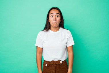 Genç melez Hintli kadın omuz silkiyor ve gözleri açık..