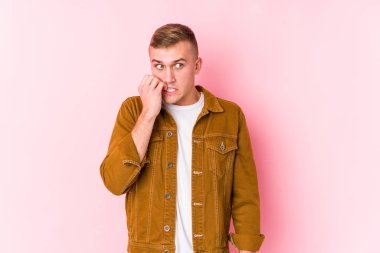 Kafkasyalı genç bir adam tırnak yiyor, gergin ve endişeli..