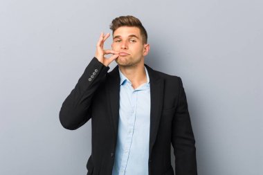 Dudaklarında bir sır tutan parmakları ile genç yakışıklı beyaz adam.