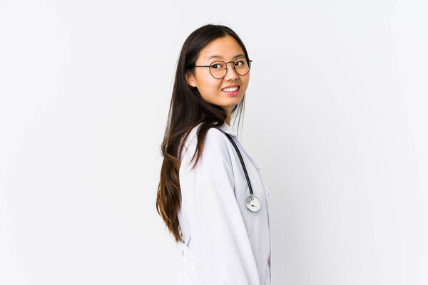 Young doctor chinese woman isolated looks aside smiling, cheerful and pleasant.