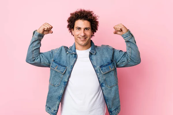 Curly Mature Man Wearing Denim Jacket Pink Background Showing Strength — 스톡 사진