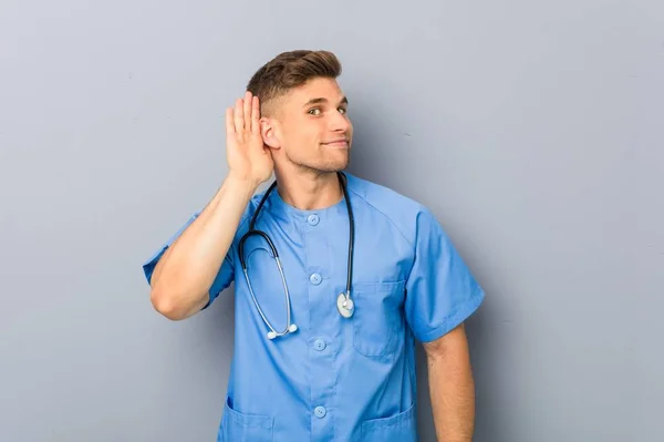 Mladý Ošetřovatel Muž Snaží Poslouchat Klepy — Stock fotografie