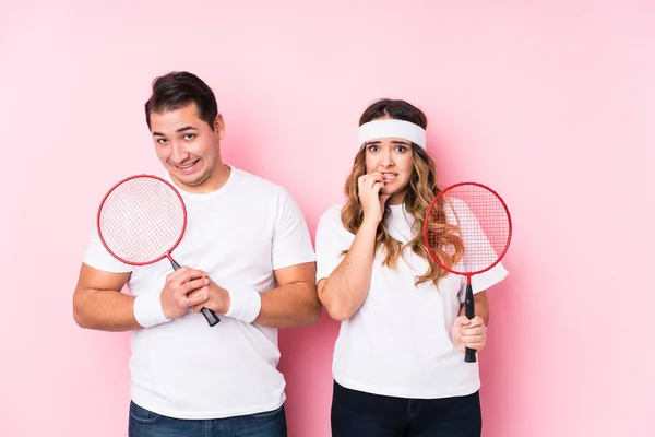Casal Jovem Jogando Badminton Isolado Mordendo Unhas Nervoso Muito Ansioso — Fotografia de Stock