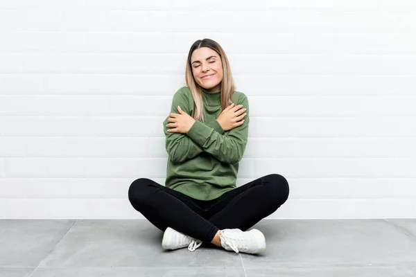 Jovem Caucasiana Sentada Chão Abraços Sorrindo Despreocupado Feliz — Fotografia de Stock