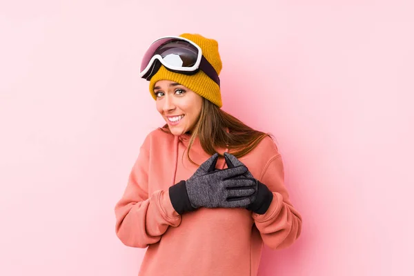 年轻的高加索女人穿着滑雪服 与外界隔绝 表情友善 将手掌压在胸前 爱情的概念 — 图库照片