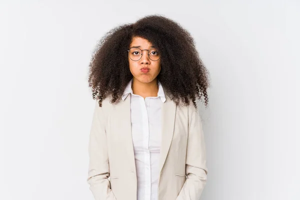 Young african american business woman blows cheeks, has tired expression. Facial expression concept.