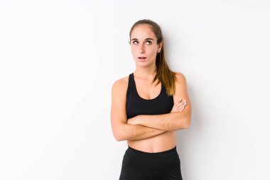 Beyaz arka planda poz veren Kafkasyalı genç kadın tekrarlanan bir görevden yoruldu.