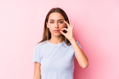 Genç, beyaz bir kadın kayak kıyafetleri giyiyor. Parmakları dudaklarında ve bir sırrı saklıyor..