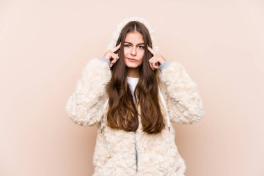 Kafkasyalı genç bir kadın yalnız poz veriyor. Bir göreve odaklanmış, parmak uçlarını işaret ediyor..