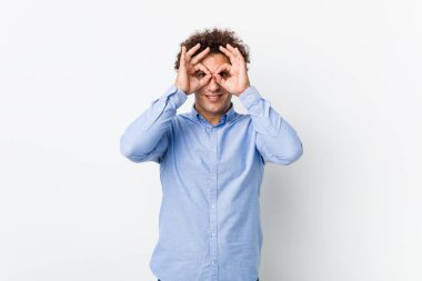 Genç, kıvırcık, olgun bir adam zarif bir gömlek giyiyor ve gözlerinin üzerinde 