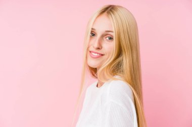 Pembe arka planda soyutlanmış genç sarışın kadın yüzü.