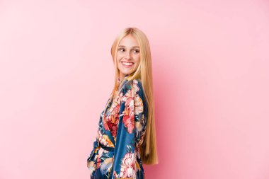 Kimono pijama giyen genç sarışın kadın gülümseyen, neşeli ve keyifli bir kenara bakar..