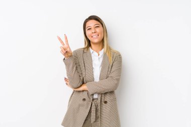 Young caucasian business woman isolated joyful and carefree showing a peace symbol with fingers.