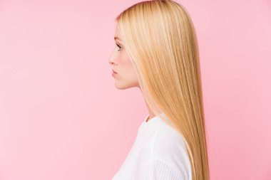 Pembe arka planda soyutlanmış genç sarışın kadın yüzü.