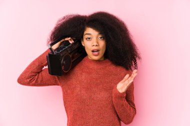 Elinde kaset tutan genç afro kadın şaşırdı ve şok oldu..