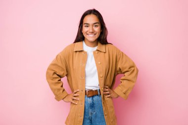 Genç melez Hintli kadın kendini izole edip ellerini kalçasında tutuyor..