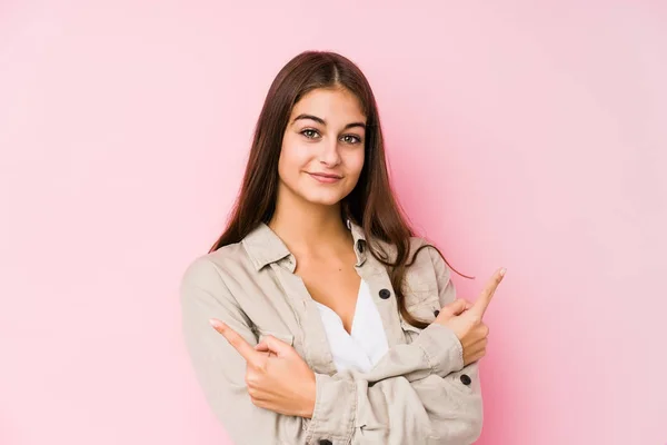 Young Caucasian Woman Posing Pink Background Points Sideways Trying Choose — 图库照片