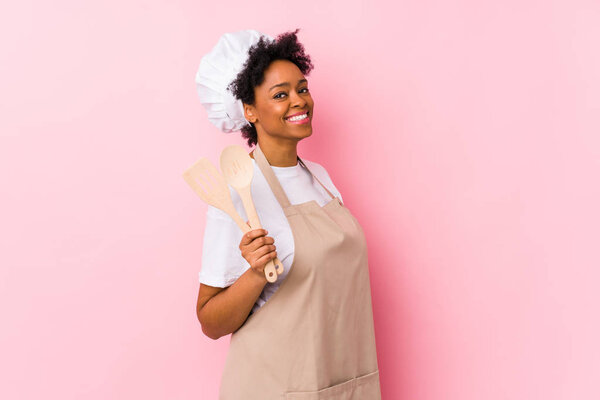 Young african american cook woman looks aside smiling, cheerful and pleasant.