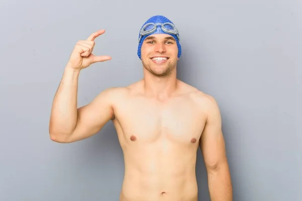 Jovem Nadador Profissional Segurando Algo Pouco Com Dedos Indicador Sorrindo — Fotografia de Stock