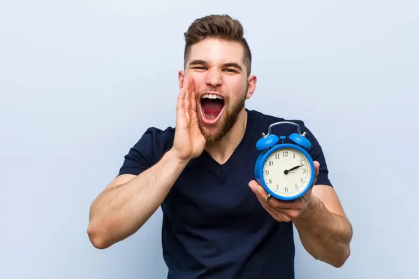 Jovem Caucasiano Segurando Despertador Gritando Animado Para Frente — Fotografia de Stock