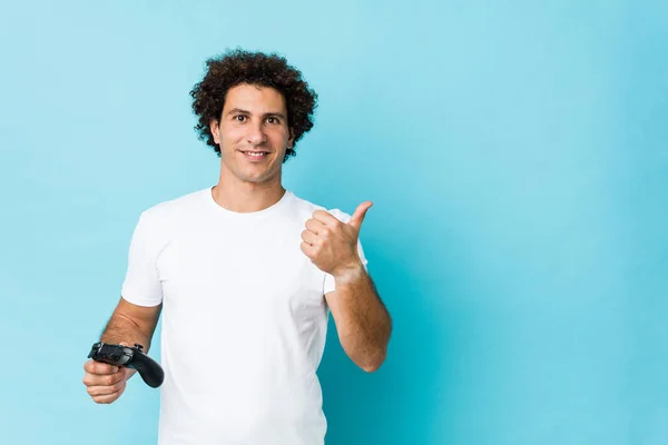 Jovem Caucasiano Encaracolado Homem Segurando Controlador Jogo Sorrindo Levantando Polegar — Fotografia de Stock