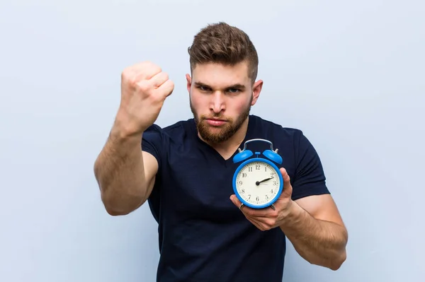 Young Caucasian Man Holding Alarm Clock Showing Fist Camera Aggressive — Stock Photo, Image