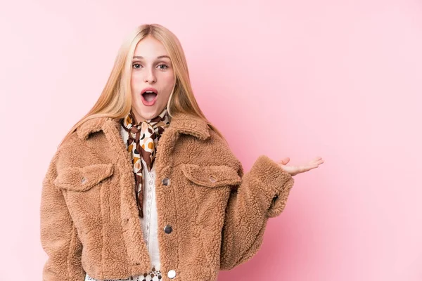 Young Blonde Woman Wearing Coat Pink Background Impressed Holding Copy — Stock Photo, Image