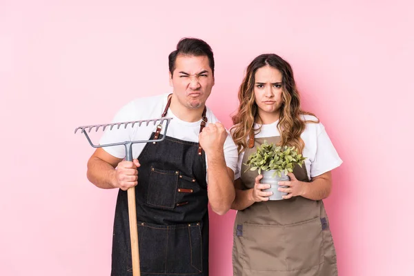 Young Couple Gardener Isolated Showing Fist Camera Aggressive Facial Expression — Stock Photo, Image