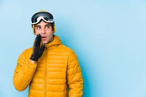 スノーボードゴーグルを身に着けている若いスキーヤーは 秘密ホットブレーキニュースを言っていると脇を見て — ストック写真