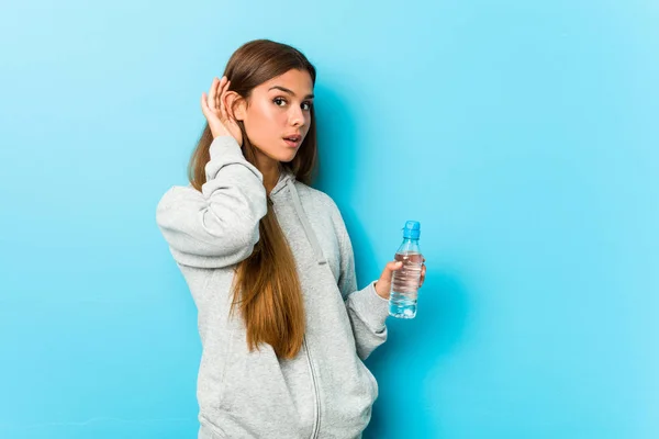 年轻的健康女人拿着水瓶想听闲话 — 图库照片
