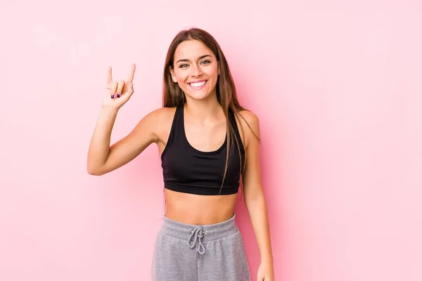 Joven Mujer Fitness Caucásica Posando Fondo Rosa Mostrando Gesto Cuernos — Foto de Stock