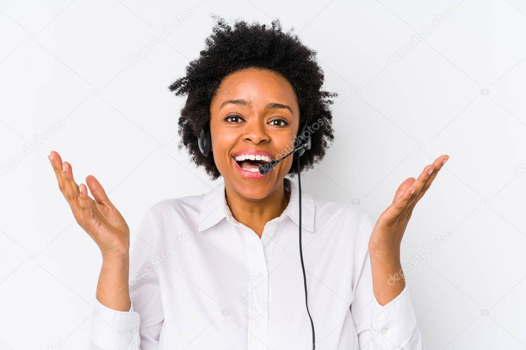Young african american telemarketer woman isolated receiving a pleasant surprise, excited and raising hands.