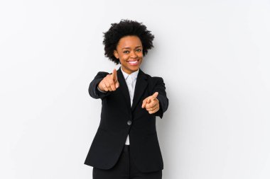 Orta yaşlı Afro-Amerikan iş kadını beyaz bir arka plana karşı yalnız, neşeli gülümsemeler ön tarafı işaret ediyor..