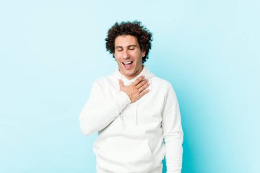 Mavi arka plandaki genç sporcu elini göğsüne koyduğunda kahkahalar atıyor..